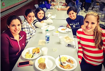 Group of female students having breakfast smiling