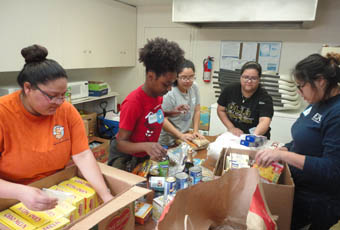 Group of students fill boxes of food at the food bank