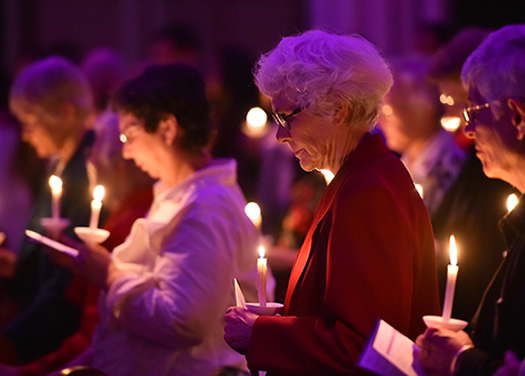 Sisters in chapel holding lite candels